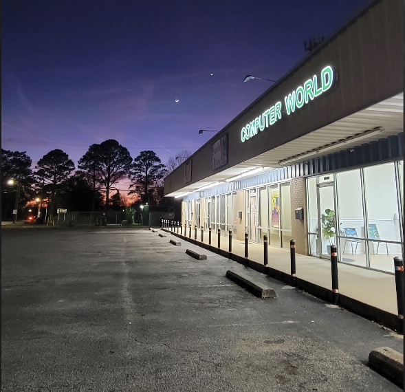 Huntsville Computer World storefront at night with the lit green COMPUTER WORLD sign on Charlotte Drive in south Huntsville